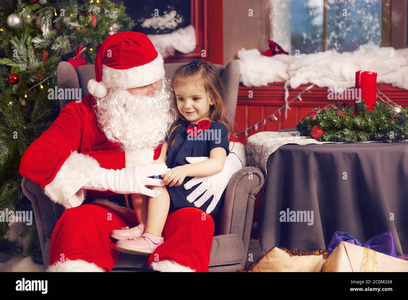 Bambina che dice il suo desiderio di Natale a Babbo Natale Foto Stock