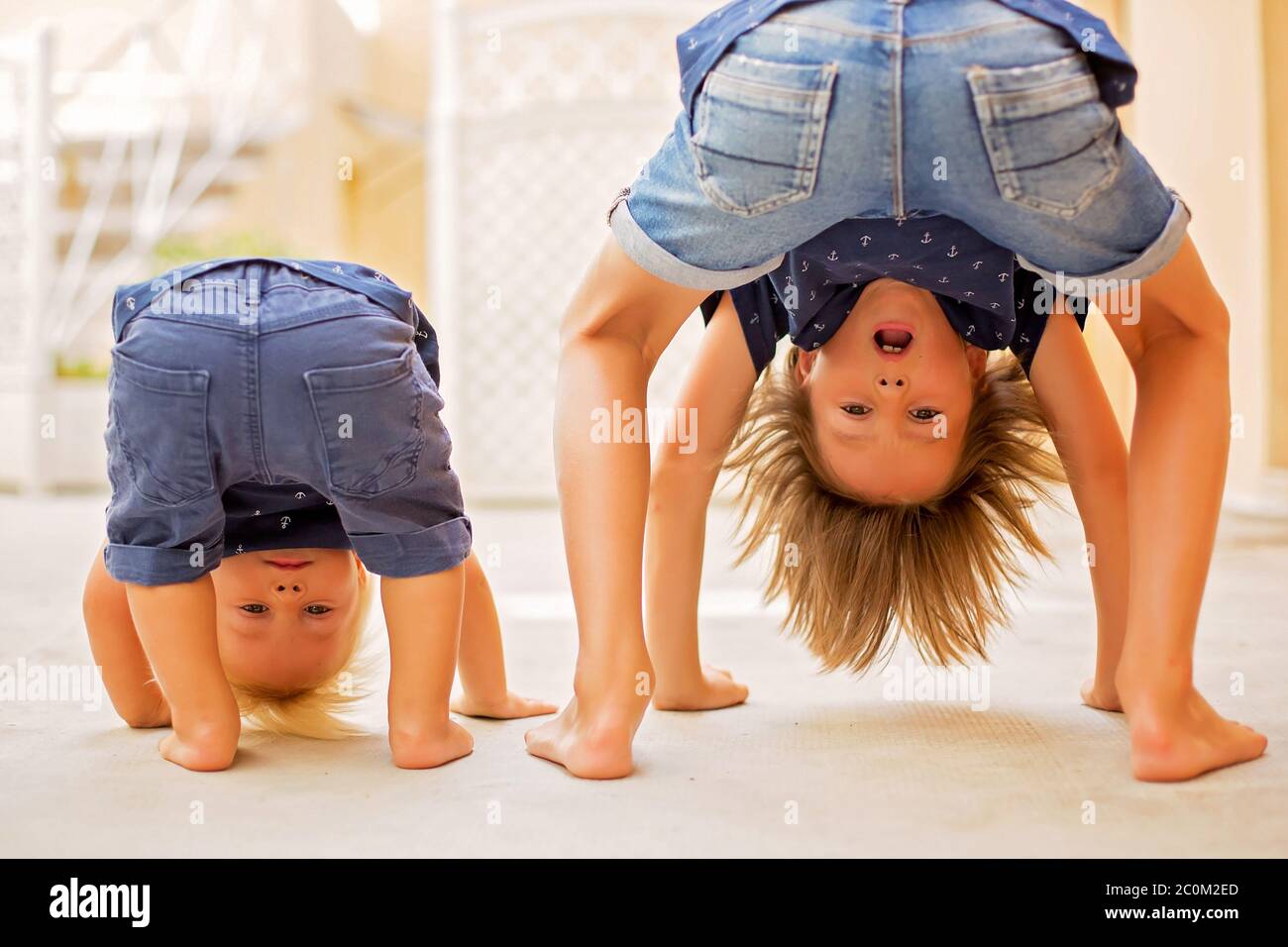 Bambino in piedi capovolto, sorridendo felice mentre si divertono Foto Stock Bambino in piedi capovolto, sorridendo felice mentre si divertono Foto Stock
