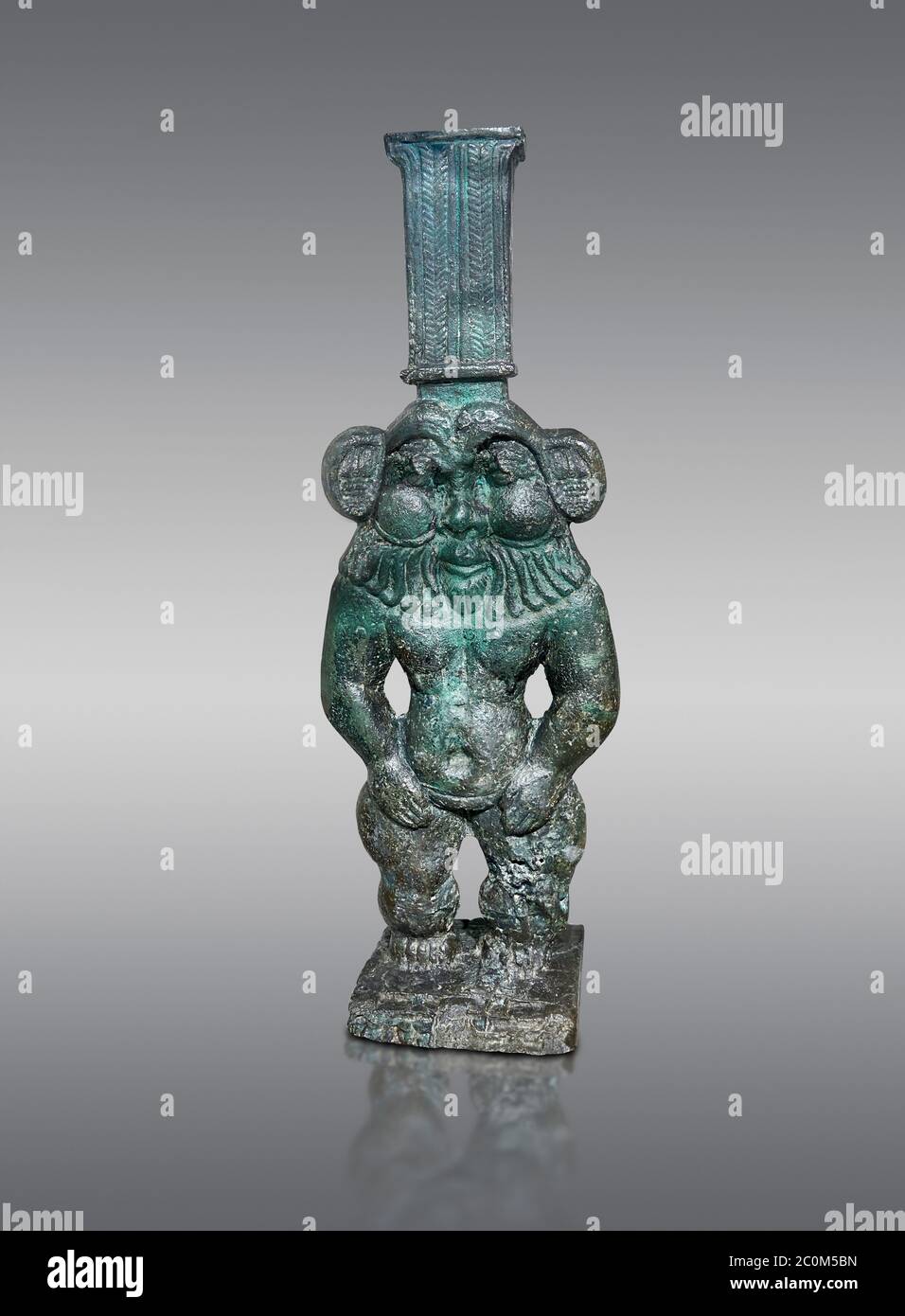 Antica statua di bronzo egiziano di Bes, Antico Regno, Museo Egizio, Torino. Sfondo grigio. Foto Stock