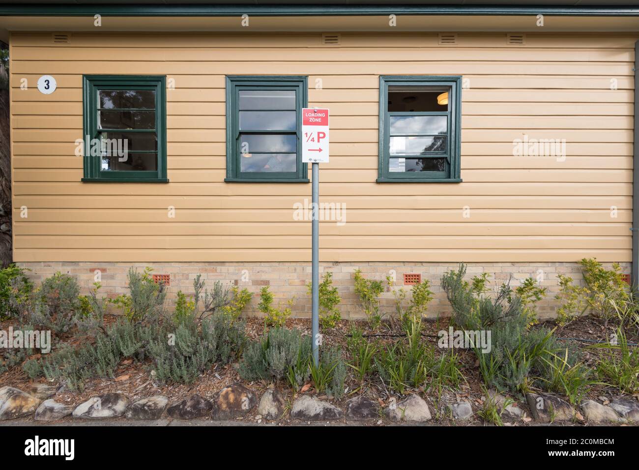 Un parcheggio di 1/4 ore al quarto o un cartello con la zona di carico in un piccolo giardino all'esterno di un edificio in legno a Middle Head, Sydney Foto Stock