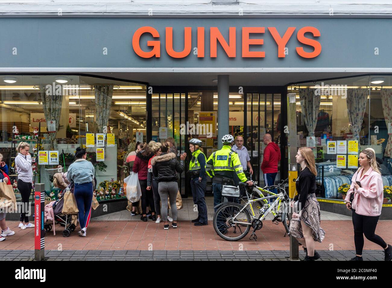 Cork, Irlanda. 12 giugno 2020. Gardai è stato chiamato al negozio Michael Guineys in Oliver Plunkett Street, città di Cork questa mattina per aiutare a controllare la folla di persone che accodano. Credit: Notizie dal vivo di AG/Alamy Foto Stock