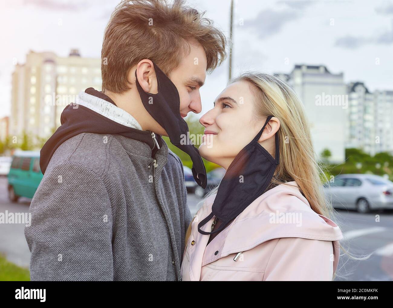 ragazzo e ragazza baciando. esprimere il desiderio di rimuovere la maschera e di essere liberi. il concetto di libertà e relazioni senza protezione... Foto Stock