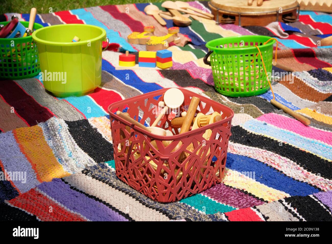 Giocattoli di legno retrò in cestino su tappeto colorato. Giocattoli antichi, stile vintage. Foto Stock