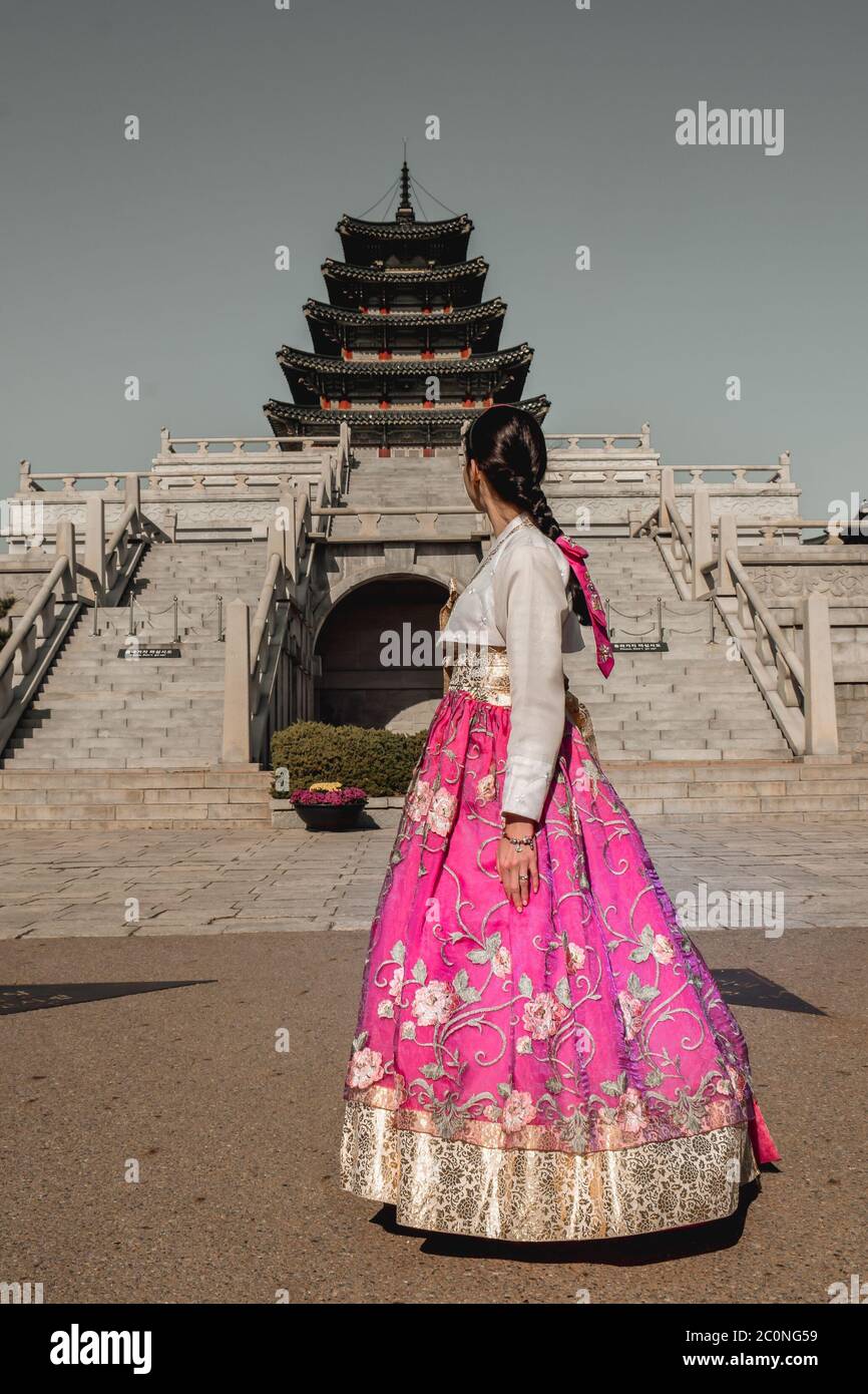 Ragazza in tradizionale gonna rosa cannello coreano costume hanbok in piedi  di fronte a un antico cinque negozi di pagoda religiosa a Seoul Corea del  Sud Foto stock - Alamy