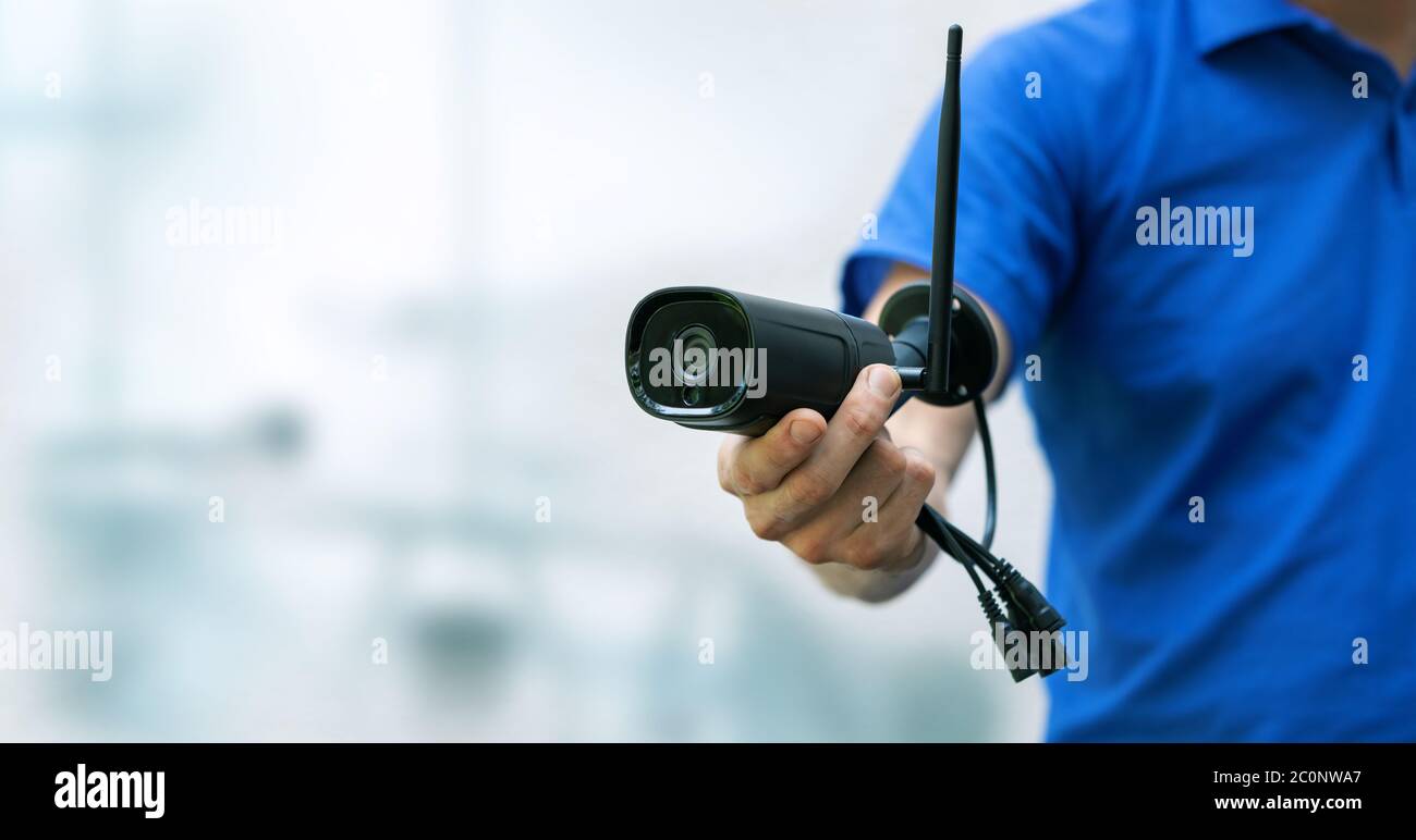 telecamere di sicurezza e servizi cctv sfondo - uomo che tiene la telecamera ip in mano con spazio di copia Foto Stock