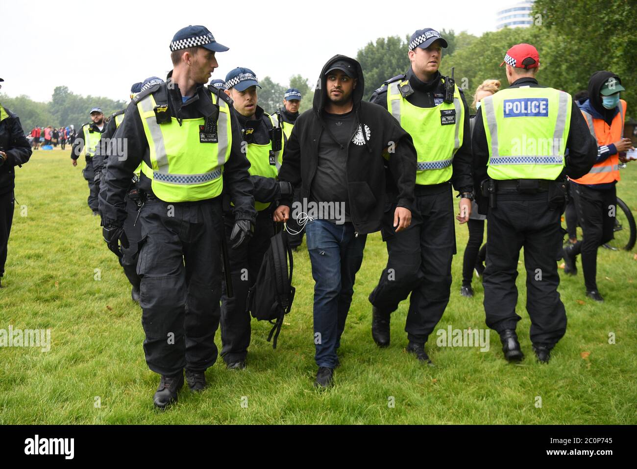 Gli ufficiali di polizia scortano un uomo lontano da un raduno di protesta Black Lives Matter ad Hyde Park, Londra. Foto Stock