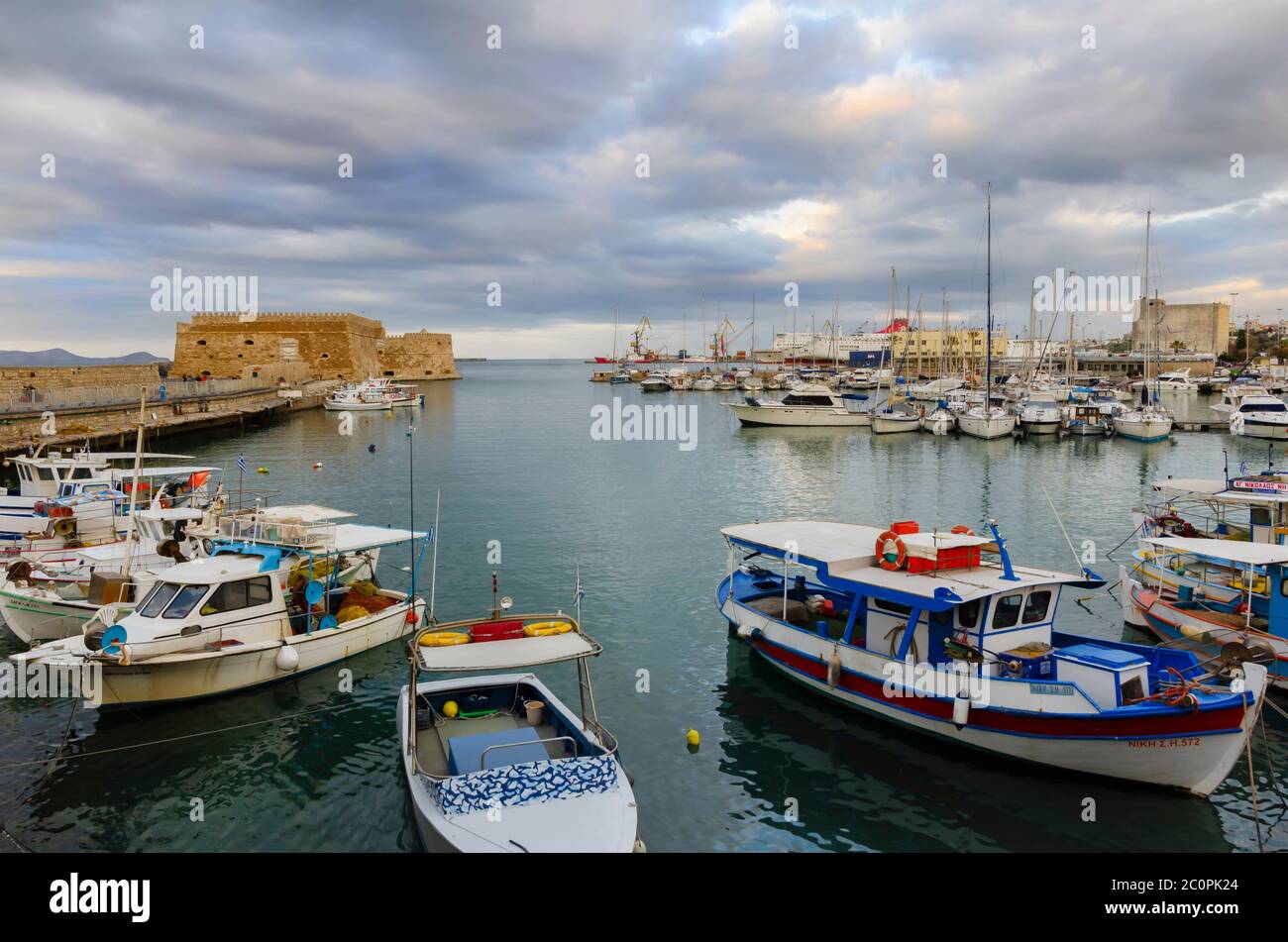 Heraklion, Creta / Grecia. Vista panoramica sul vecchio porto veneziano. Barche da pesca tradizionali e colorate sono attraccate. Fortezza veneziana Koules Foto Stock