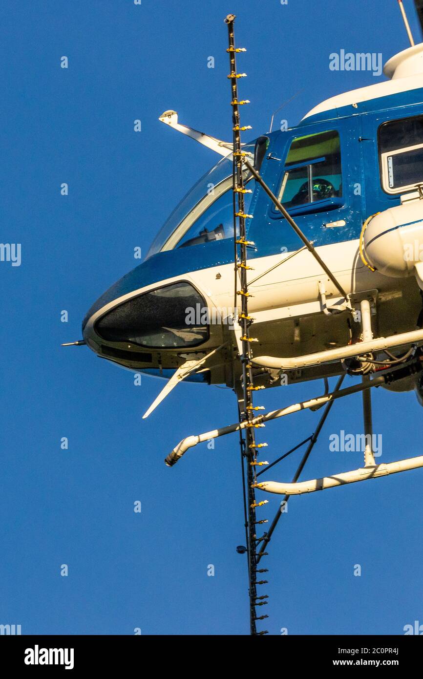 Un elicottero ha puntato per l'agricoltura che si estende sulla sua strada per un frutteto di mandorle nella Valle Centrale della California USA Foto Stock