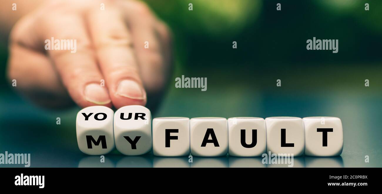 La mano trasforma i dadi e cambia l'espressione "mia colpa" in "vostra colpa". Foto Stock