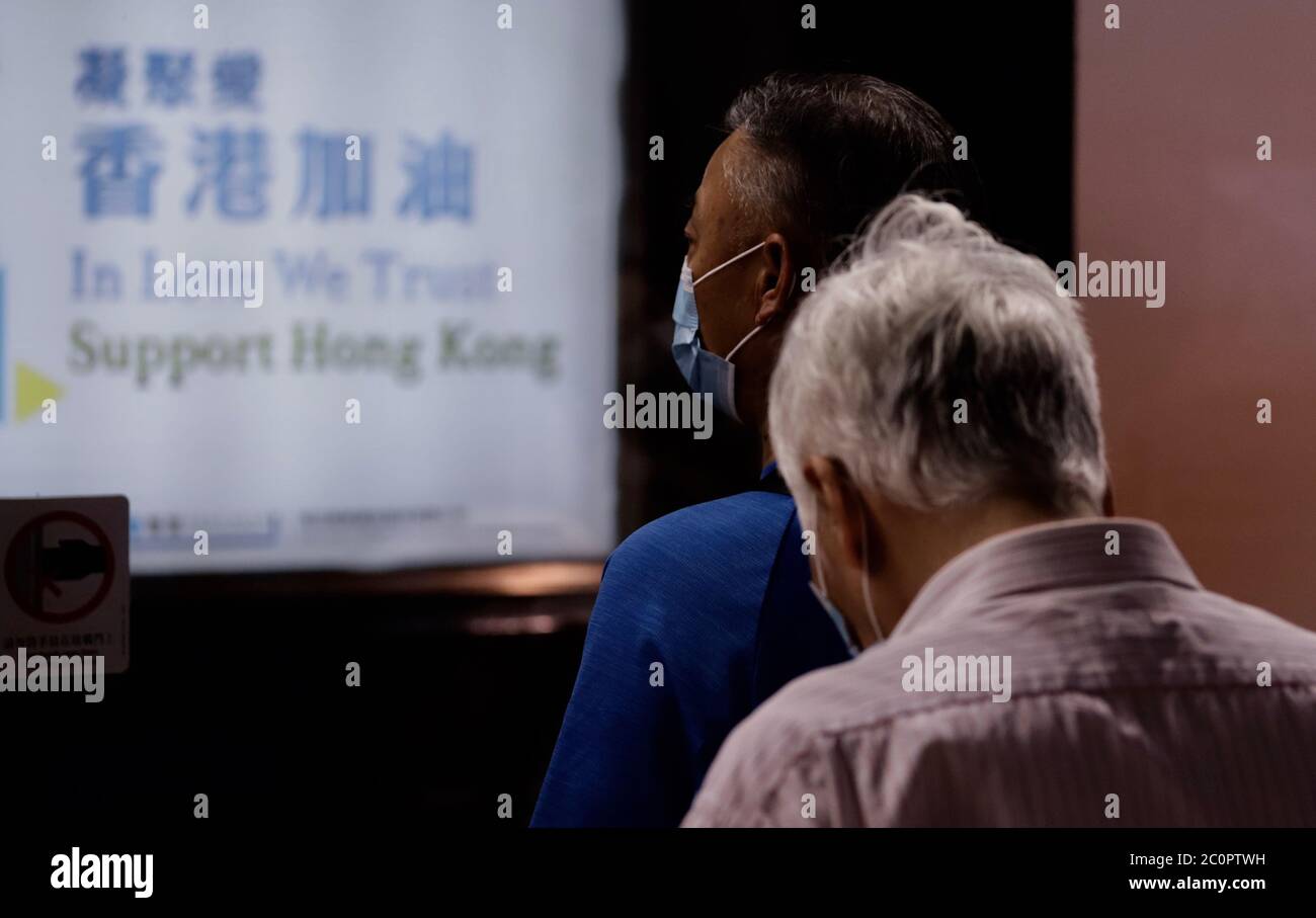 Hong Kong, CINA. 12 giugno 2020. Passeggeri in attesa di salire a bordo del treno MTR. Hong Kong governo propaganda lightbox all'interno della stazione MTR visualizzare uno slogan che è scritto: GATHER LOVE, HONG KONG 'ADD-OIL' ( Cheer Up ).June-12, 2020 Hong Kong.ZUMA/Liau Chung-ren Credit: Liau Chung-ren/ZUMA Wire/Alamy Live News Foto Stock