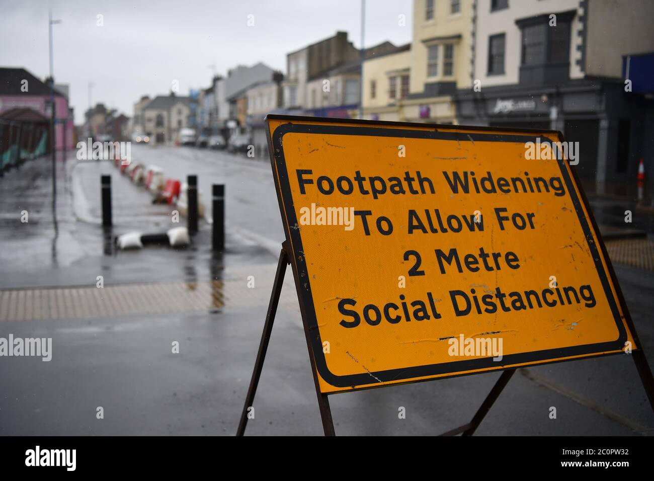 Hartlepool, County Durham - UN cartello stradale temporaneo dice al pubblico di ampliare il sentiero per consentire la regola di distanziamento sociale di 2 metri in Inghilterra. Foto Stock