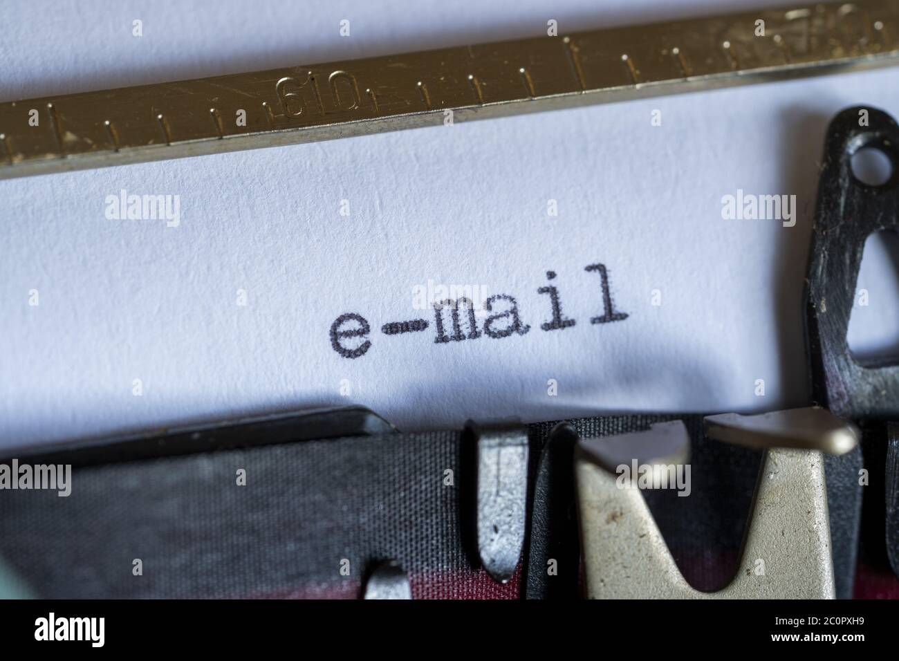 Digitando la parola "e-mail" su una macchina da scrivere d'epoca. Primo piano, messa a fuoco selettiva. Foto Stock