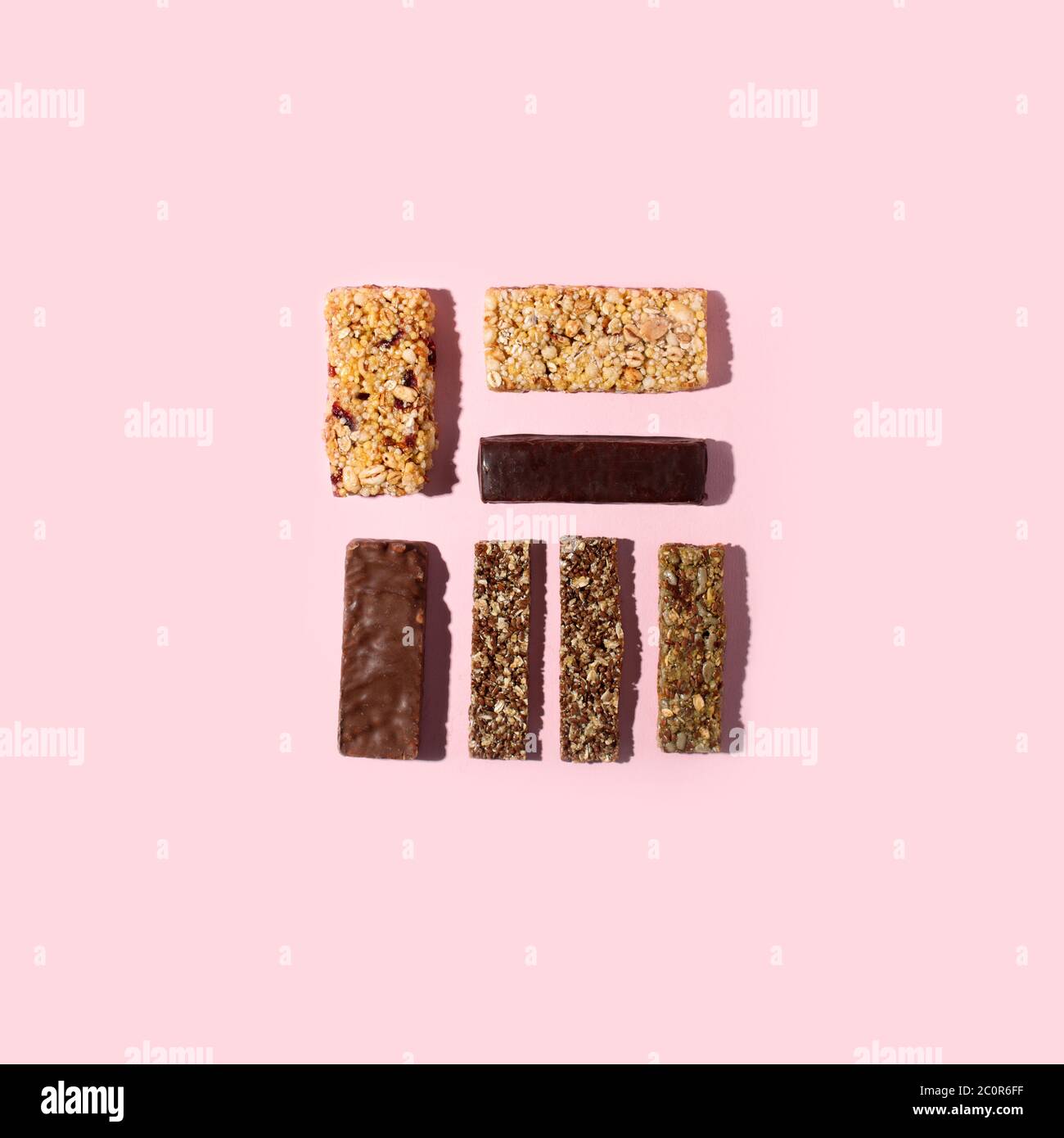 Set di cereali misti senza glutine, semi, barretta energetica proteica con frutta secca e vari tipi di frutta secca, fondo rosa. Cibo vegano sano super, fitness Foto Stock