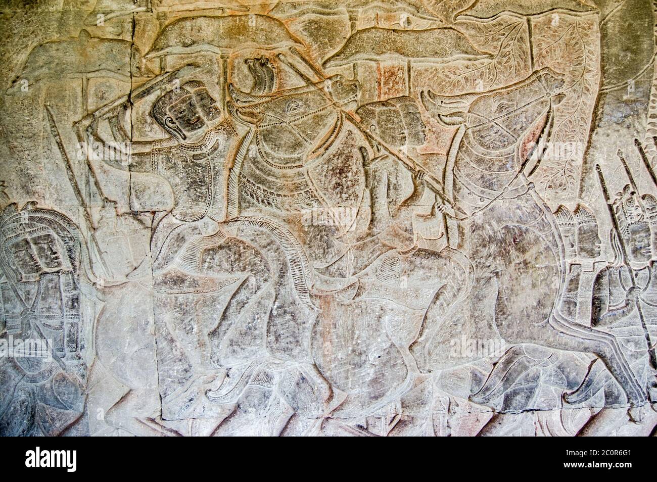 Antica scultura in bassorilievo di soldati di cavalleria che agitavano le loro armi in battaglia. Galleria meridionale del Tempio di Angkor Wat, Siem Reap, Cambogia. Scolpito in t Foto Stock