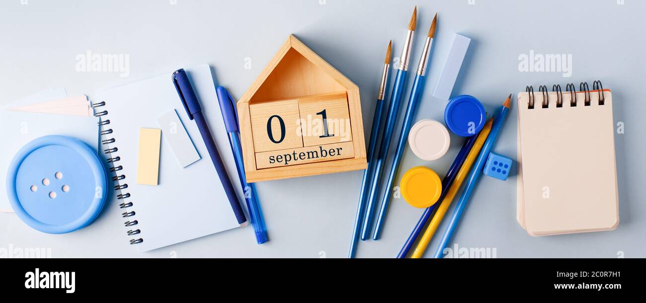 1 septemder, giorno di conoscenza, forniture scolastiche su sfondo blu. Concetto di ritorno a scuola, sfondo monocromatico elegante, piatto, mock up, desi Foto Stock