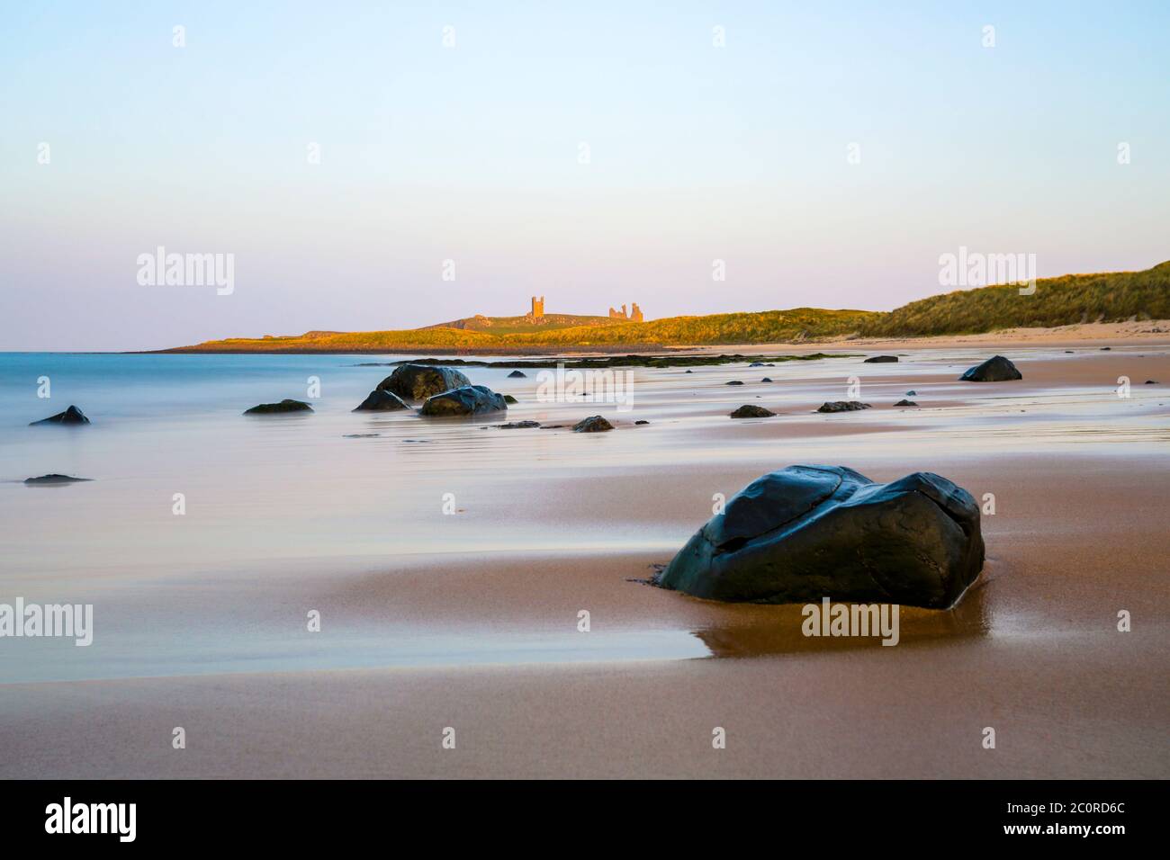 Castello di Dunstanburgh al tramonto, Northumberland Foto Stock