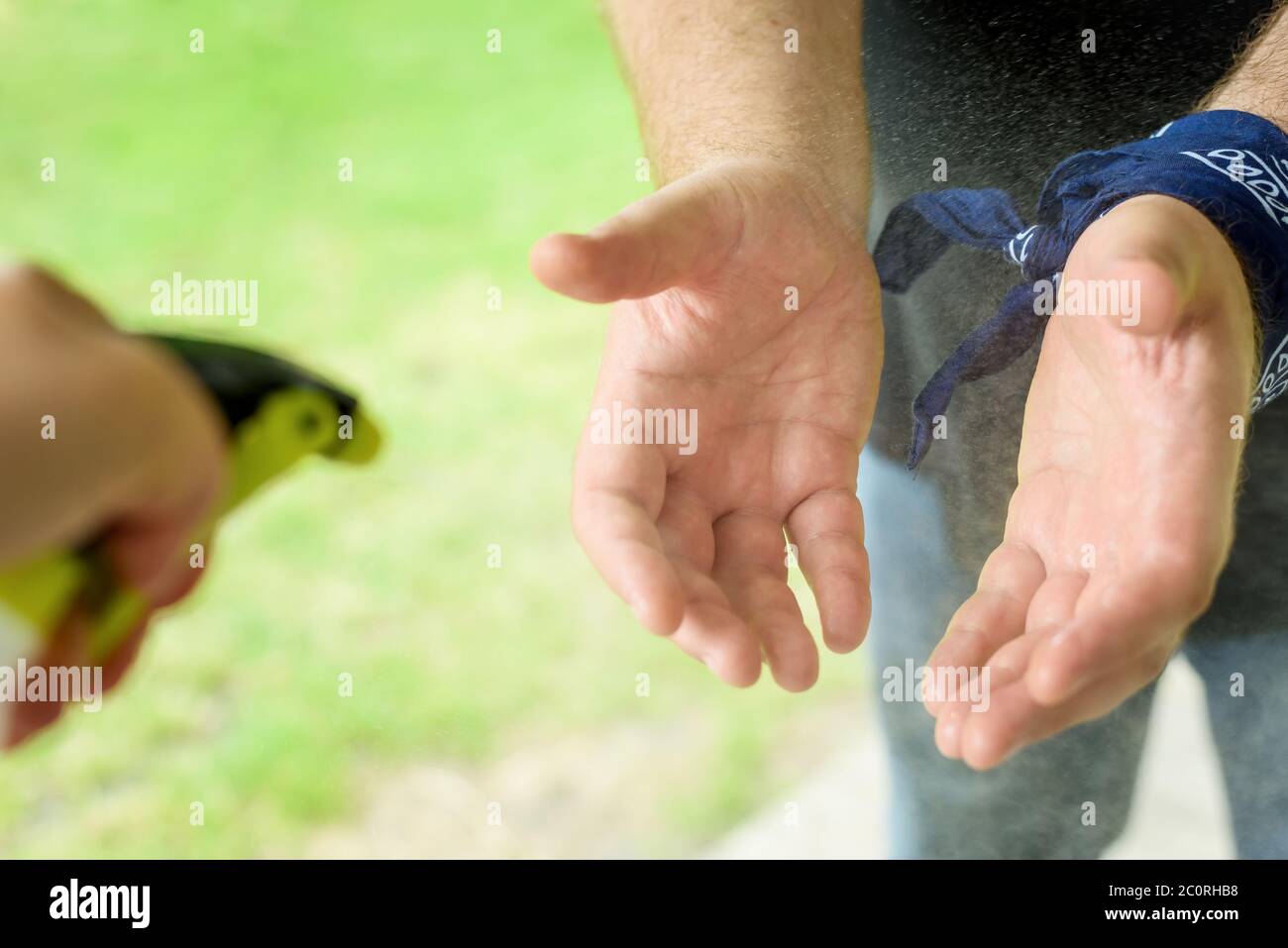 l'uomo disinfetta le mani prima di entrare nel giardino della spiaggia del club cittadino Foto Stock