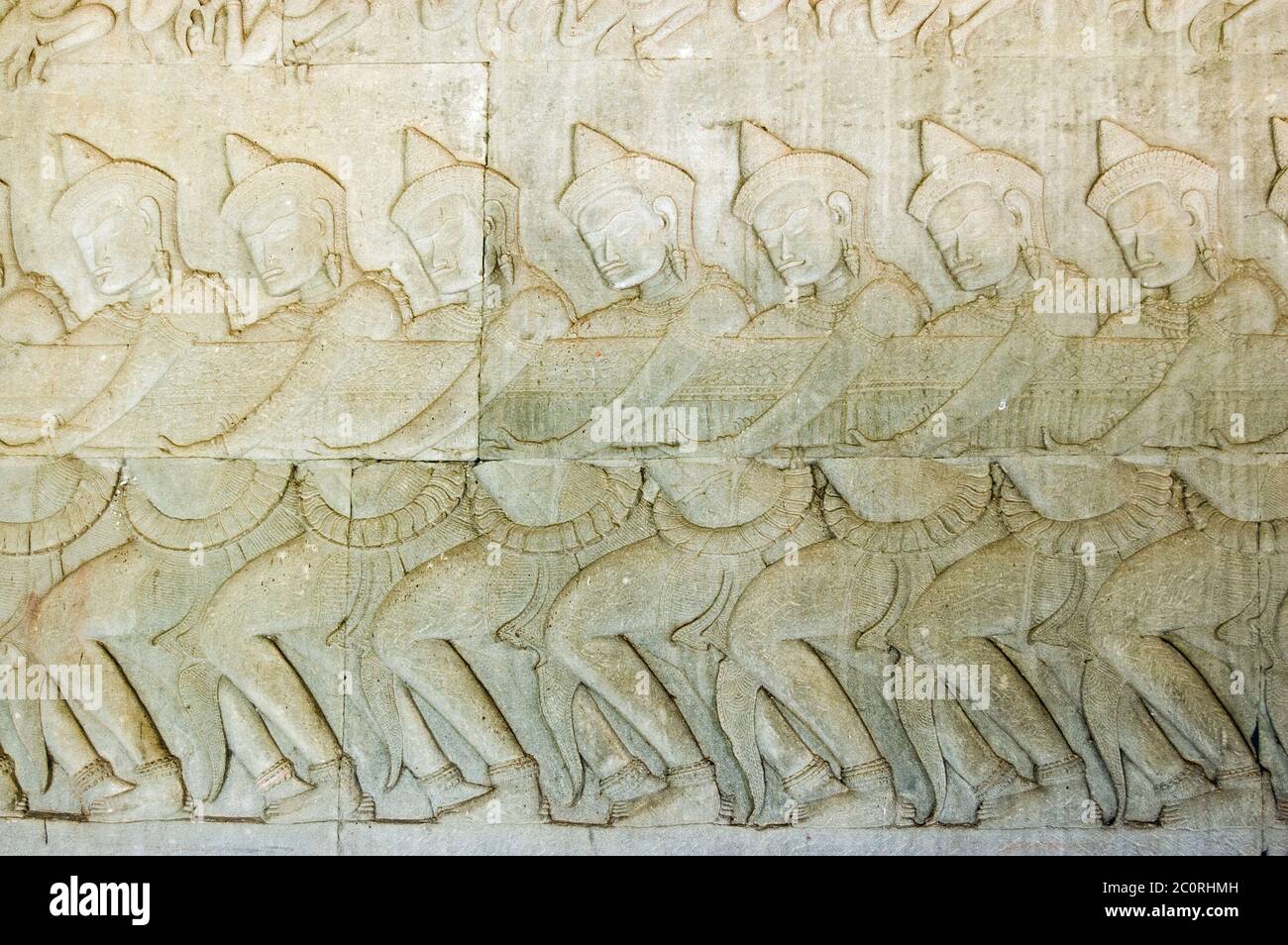 Antica scultura in bassorilievo Khmer che mostra una fila di divinità indù, devas, tirando sul serpente Vasuki. Leggenda della zaffa dell'oceano del latte, Angkor Foto Stock