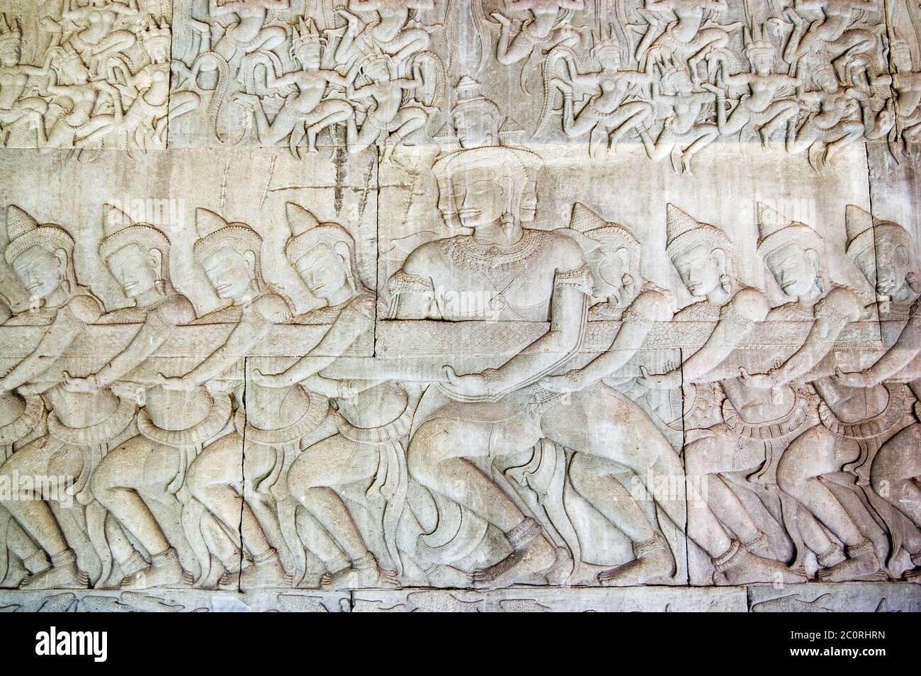 Antica scultura in bassorilievo Khmer che mostra una fila di divinità indù, devas, tirando sul serpente Vasuki. Leggenda della zaffa dell'oceano del latte, Angkor Foto Stock