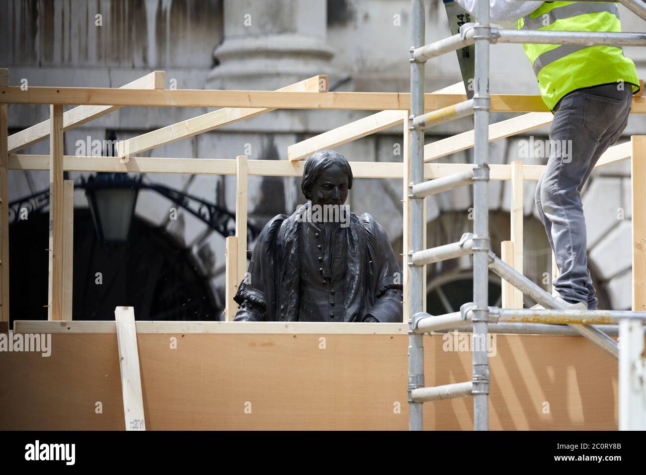 Londra, Regno Unito. - 12 giu 2020: La statua di Thomas Guy è stata imbarcata prima di essere rimossa dalla sua posizione in un cortile dell'ospedale che ha aiutato trovato. Thomas Guy si dice abbia fatto la sua fortuna da azioni in una società che è stata coinvolta nel commercio degli schiavi. Foto Stock