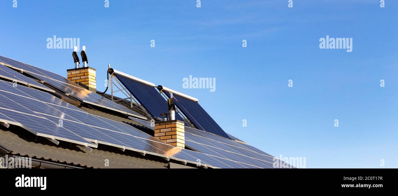 Impianto solare per la generazione di energia elettrica e acqua verde riscaldamento sul tetto di una casa residenziale Foto Stock