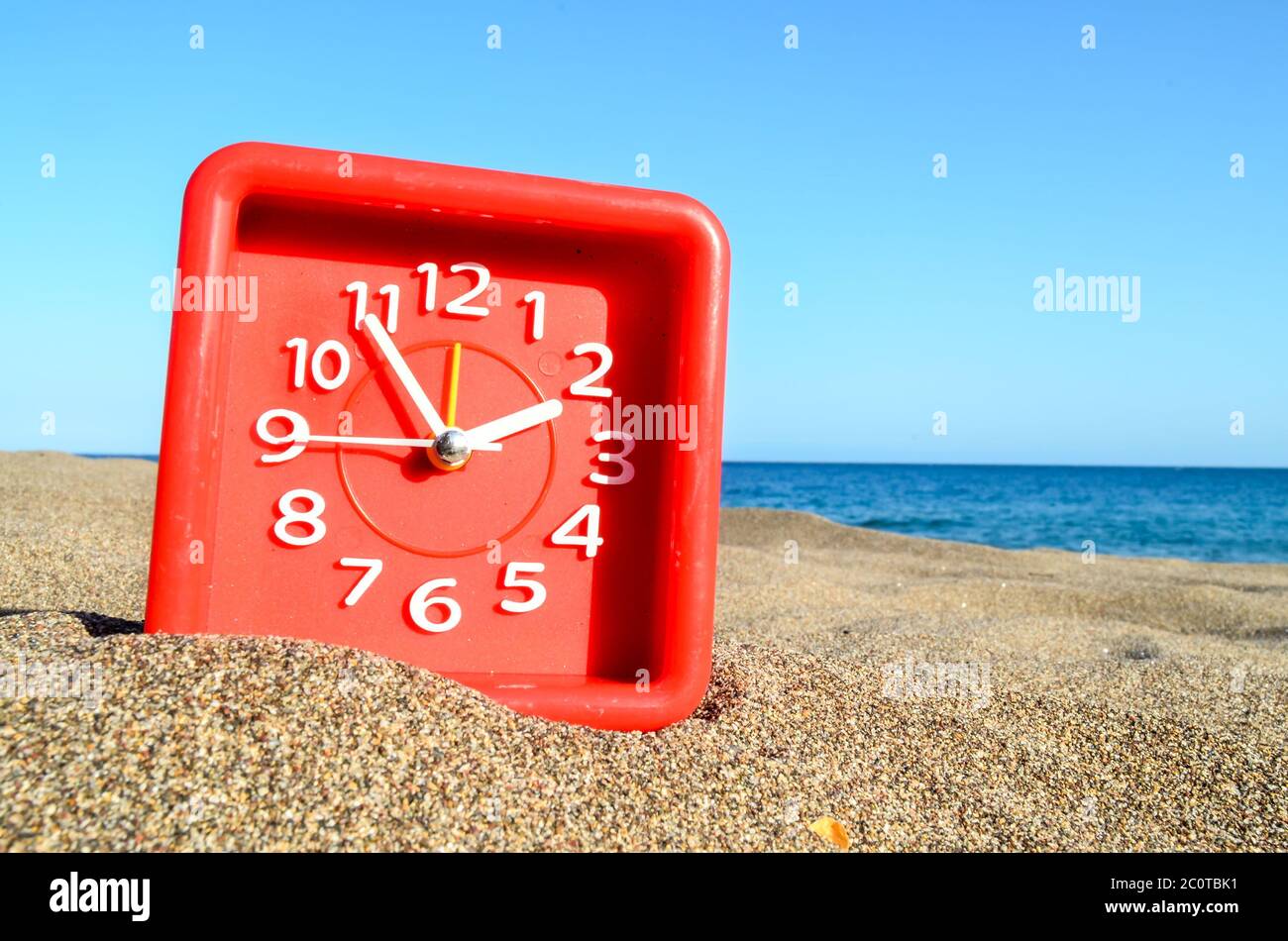 Orologio sulla spiaggia di sabbia Foto stock - Alamy