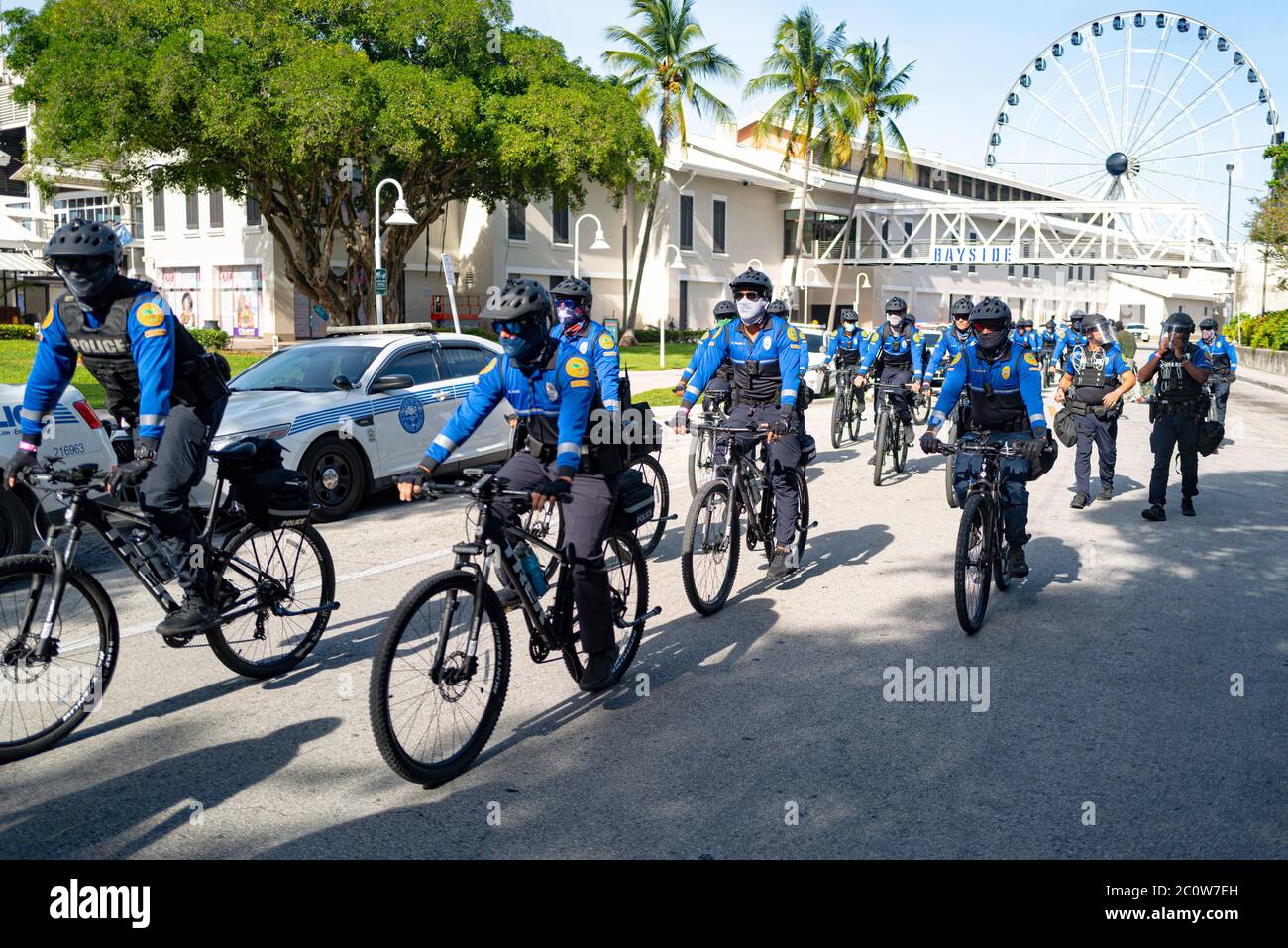 Miami Downtown, FL, USA - 31 MAGGIO 2020: Pattuglia americana della polizia delle biciclette in maschere protettive. La polizia di Miami durante una pandemia. Protezione Bayside Foto Stock