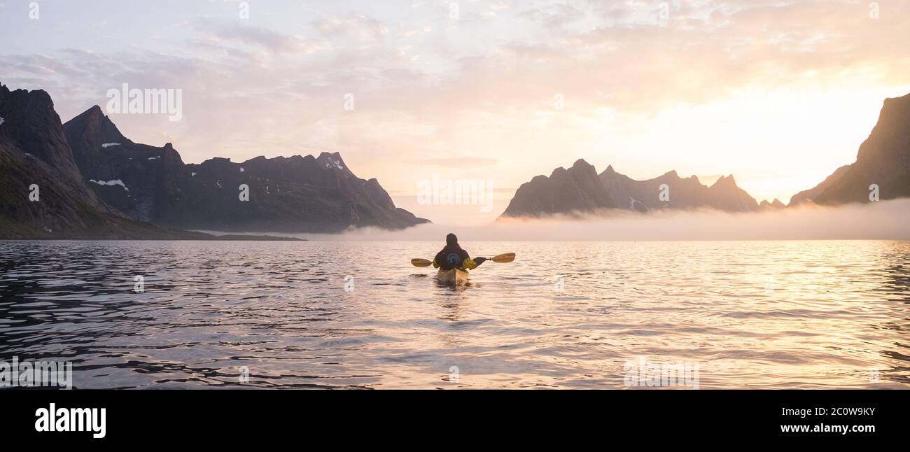 Un kayak che esplora Reinefjorden a mezzanotte Foto Stock