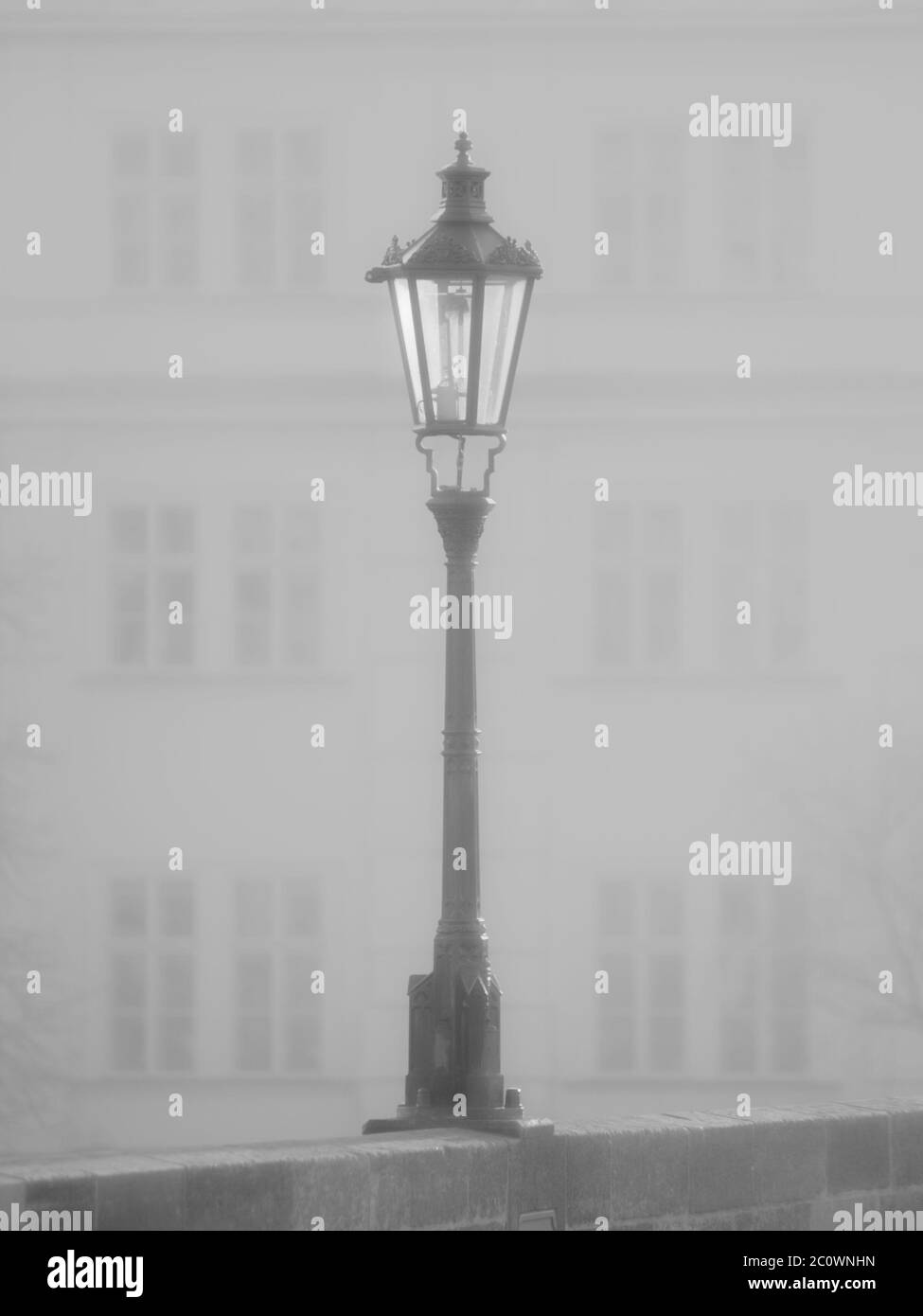 Lampada di strada sul Ponte Carlo in mattinata nebbia, Praga, Repubblica Ceca. Immagine in bianco e nero. Foto Stock