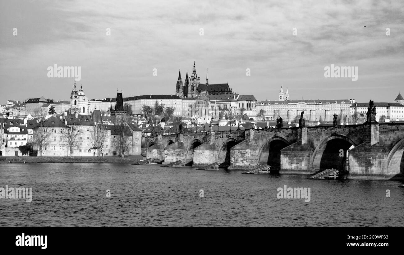 Panorama Hradcany di Praga in giornata di sole. Ponte Carlo sul fiume Moldava con il Castello di Praga, Repubblica Ceca. Immagine in bianco e nero. Foto Stock