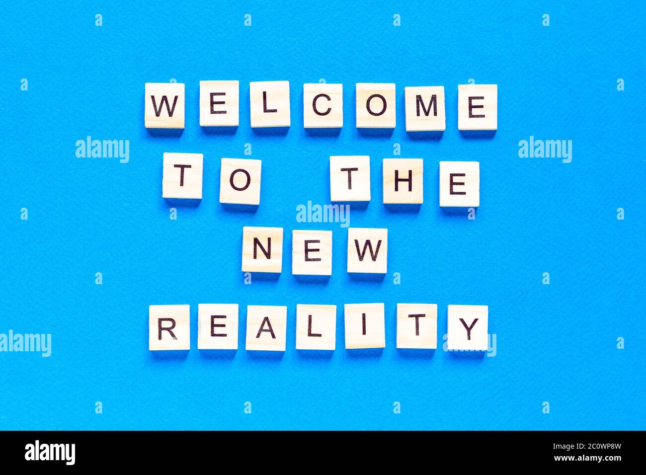 l'iscrizione accoglie la nuova realtà in lettere di legno su sfondo blu, vista dall'alto. Tecnologie moderne, un nuovo dispositivo del wor Foto Stock