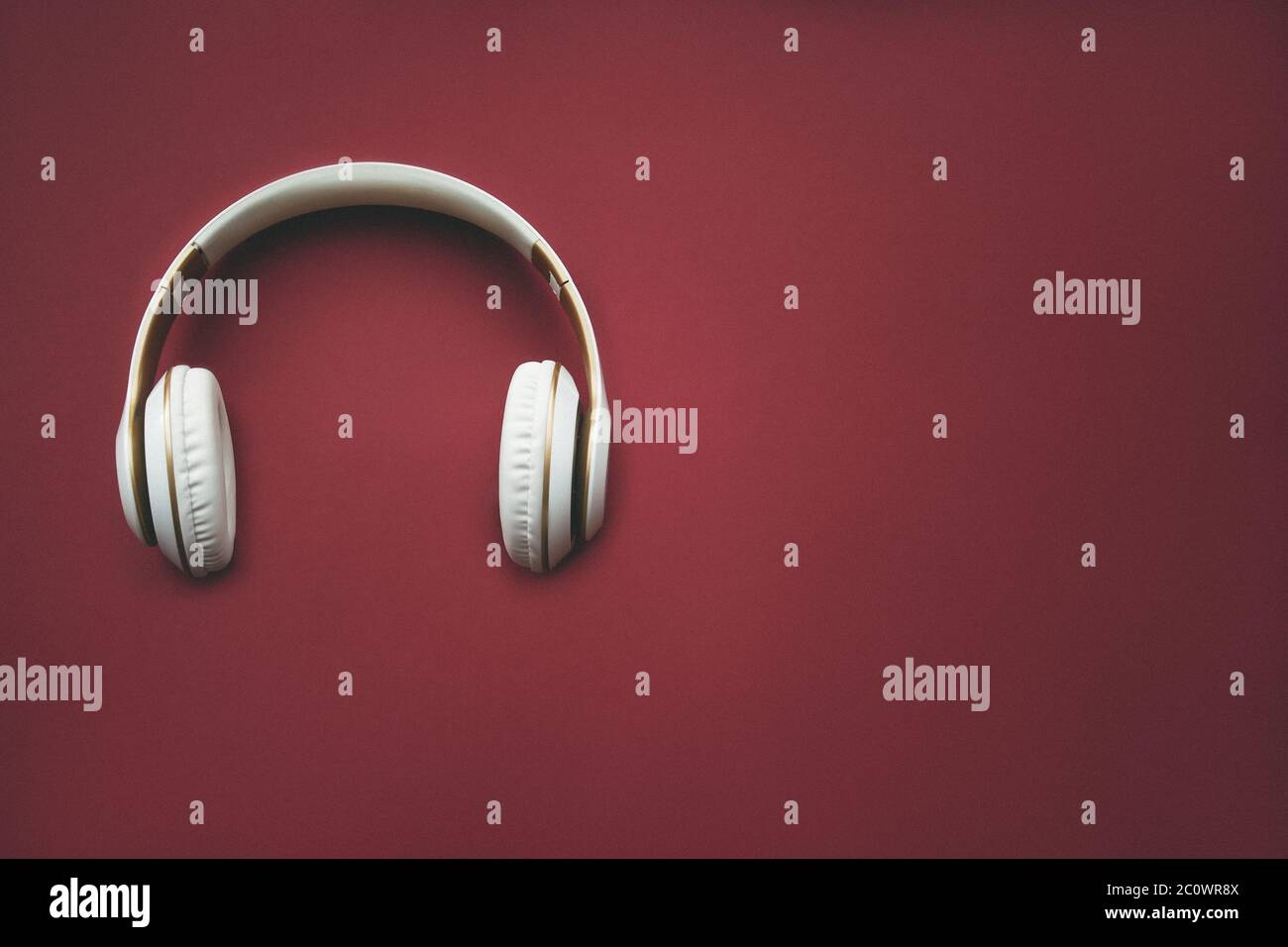 Direttamente sopra l'immagine delle cuffie su sfondo rosso. Concetto musicale. Concetto minimo Foto Stock