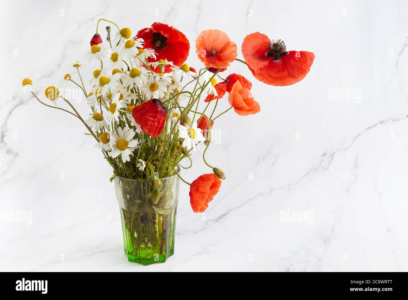 Bouquet di fiori selvatici papavero e margherita su sfondo marmoreo. Sfondo floreale. Foto Stock