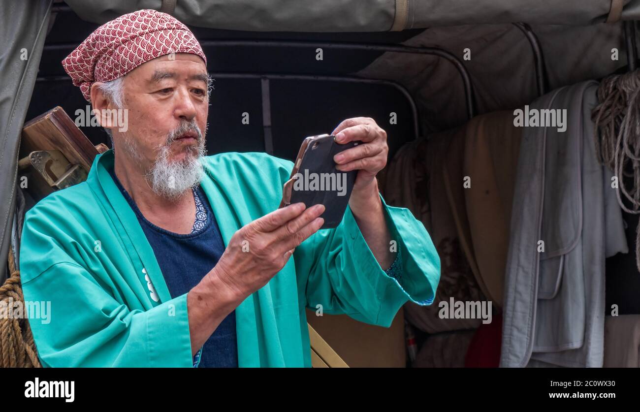 Vecchio giapponese con smartphone a Shibuya, Tokyo, Giappone Foto Stock