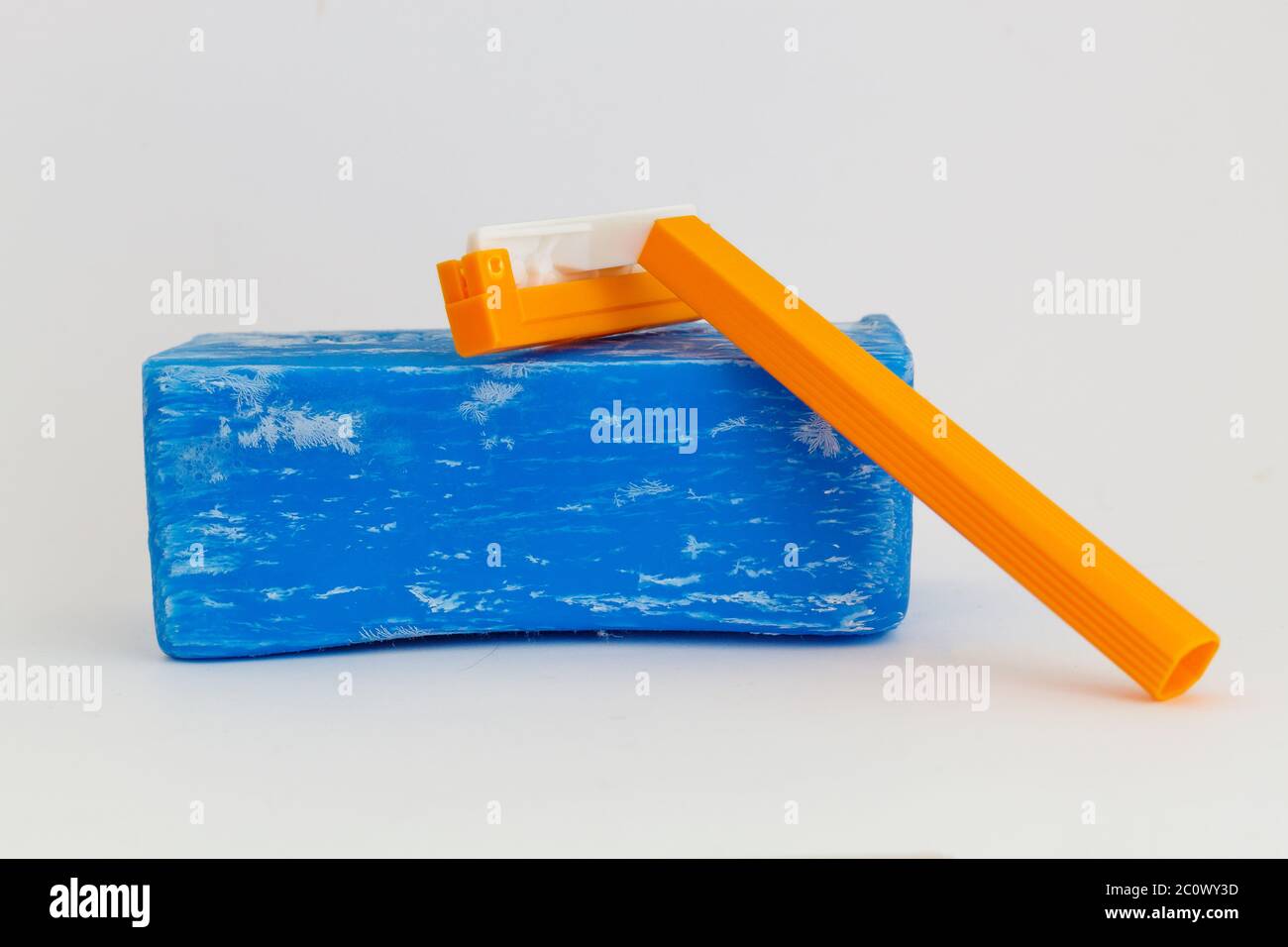 Sapone di lavaggio blu e rasoio di rasatura arancione su sfondo grigio Foto Stock