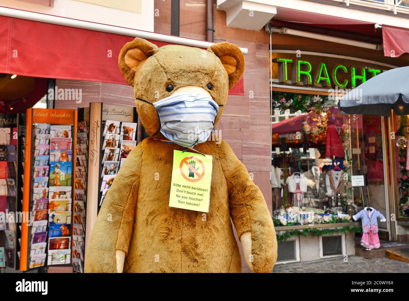 Orsacchiotto gigante giocattolo con una maschera durante la crisi di Coronavirus nel fornt di negozio turistico a Francoforte, Germania Foto Stock