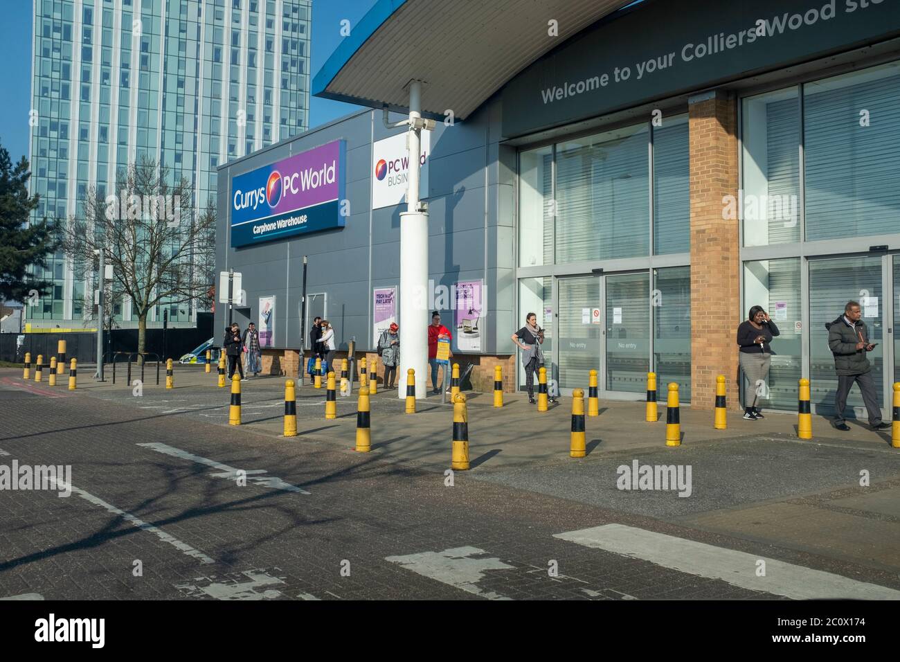Covid19, custumers coda fuori negozio in Colliers Wood al dettaglio nei primi giorni del blocco, Colliers legno al dettaglio Park, Londra Foto Stock