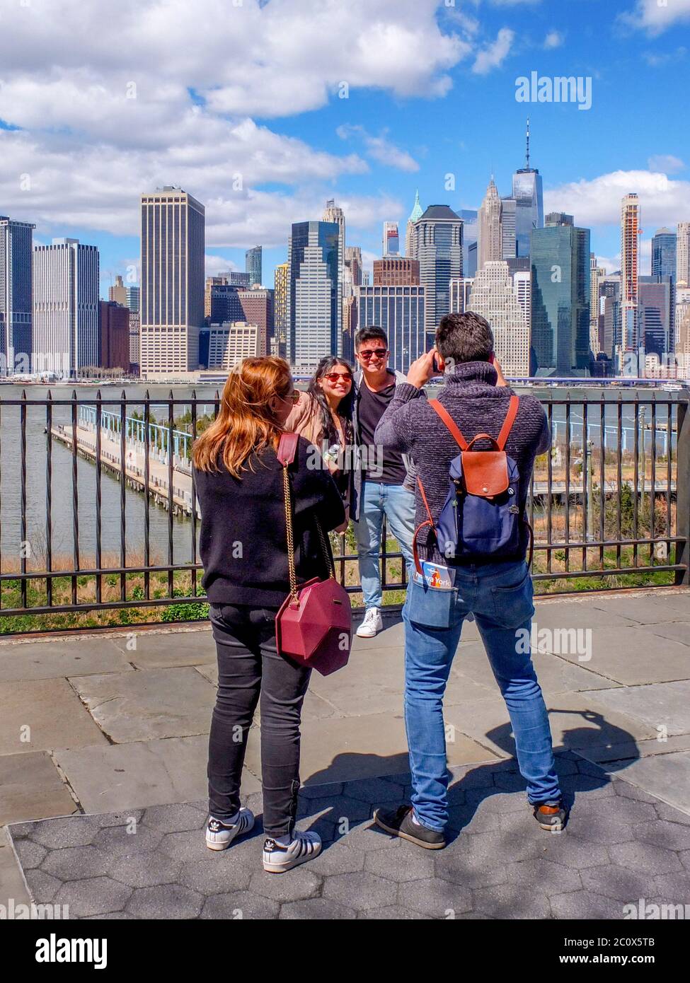 Cinque turisti ammirano lo skyline di New York City a Lower Manhattan dalla Promenade su Brooklyn Heights. Foto Stock