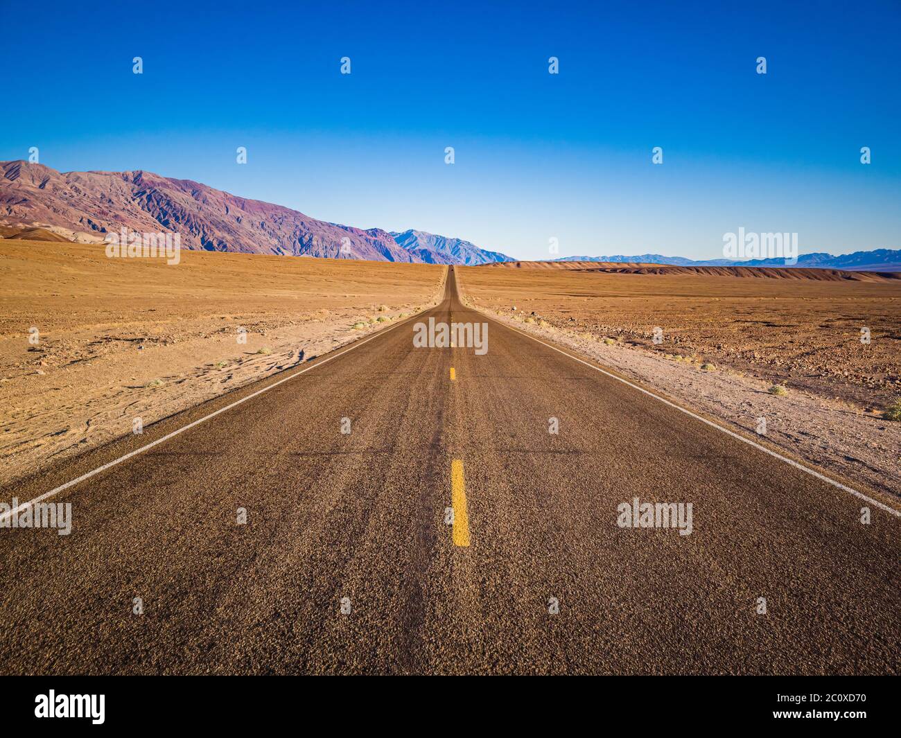 La corsia di Endless Straight Badwater Road che attraversa lo scenario arido della famosa Death Valley, California. È uno dei posti più caldi in t Foto Stock