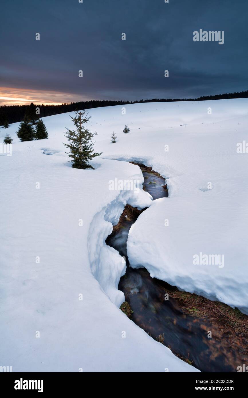 fiume di montagna in inverno durante il sole giù Foto Stock