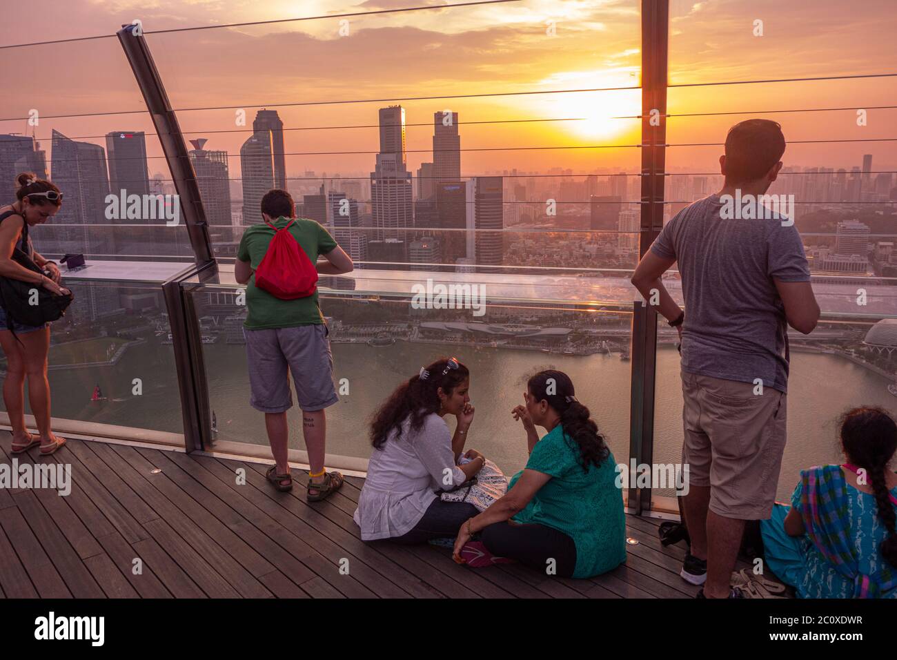 La gente osserva il tramonto sullo skyline del centro di Singapore, visto dalla terrazza dell'hotel Marina Bay Sands. Singapore Foto Stock