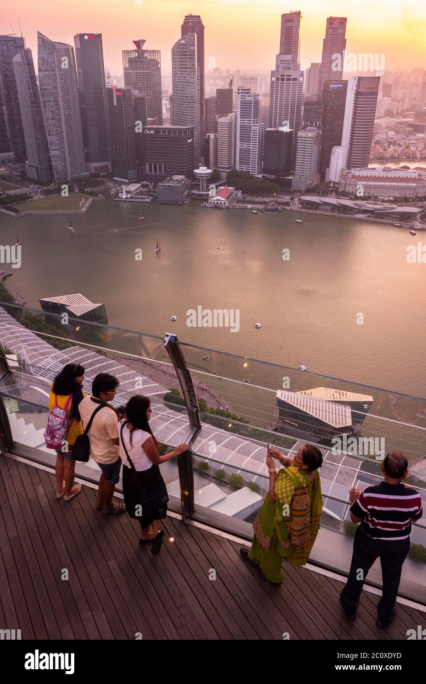 La gente osserva il tramonto sullo skyline del centro di Singapore, visto dalla terrazza dell'hotel Marina Bay Sands. Singapore Foto Stock