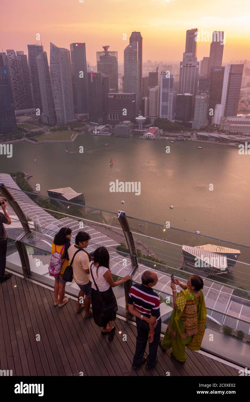 La gente osserva il tramonto sullo skyline del centro di Singapore, visto dalla terrazza dell'hotel Marina Bay Sands. Singapore Foto Stock