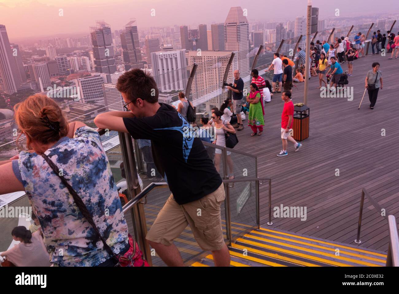 La gente osserva il tramonto sullo skyline del centro di Singapore, visto dalla terrazza dell'hotel Marina Bay Sands. Singapore Foto Stock