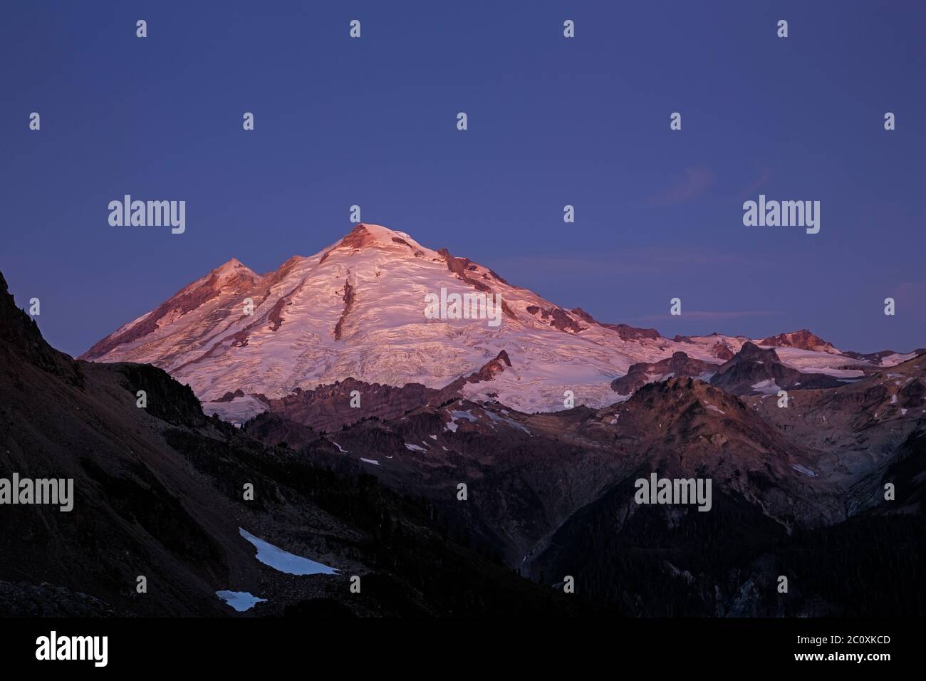 WA16706-00...WASHINGTON - i colori rosey dell'alba che scaldano il Monte Baker nella zona selvaggia del Monte Baker - Snqualmie National Forest. Foto Stock