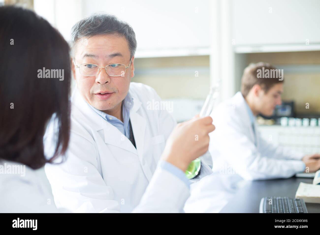 Persone che fanno di esperimento di chimica in laboratorio moderno Foto Stock