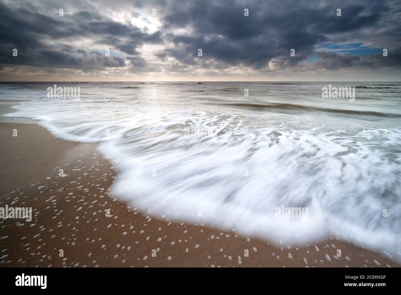 Onde del mare del Nord sulla spiaggia di sabbia Foto Stock