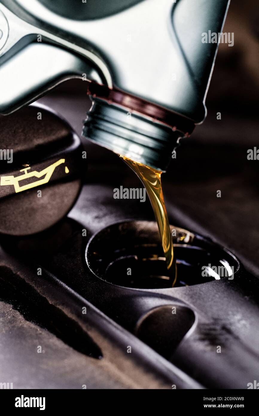 Olio fresco che viene versato durante un cambio dell'olio per un auto Foto Stock Olio fresco che viene versato durante un cambio dell'olio per un auto Foto Stock