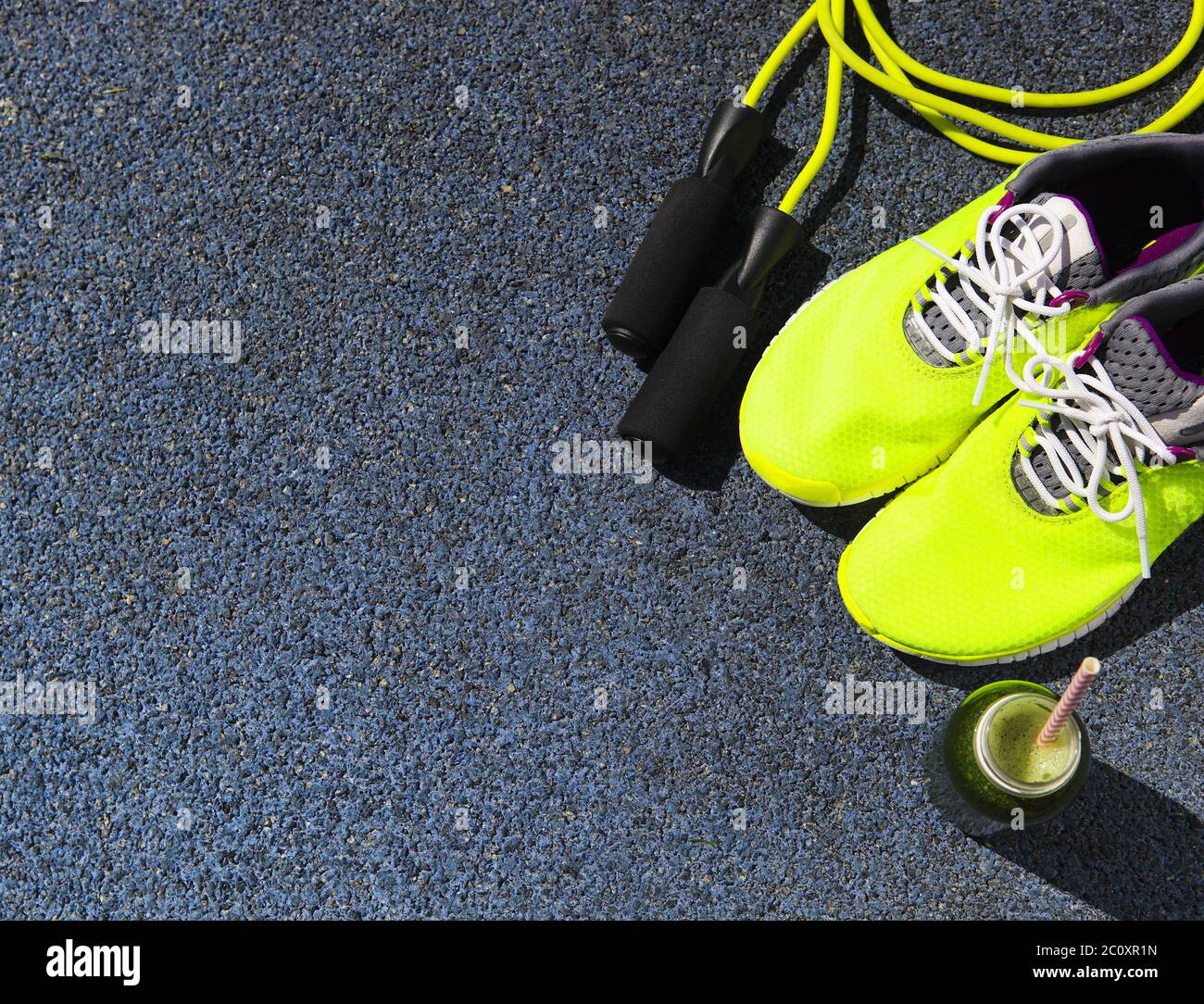 Scarpe da running, corda da salto e bottiglia da bere con succo verde Foto  stock - Alamy
