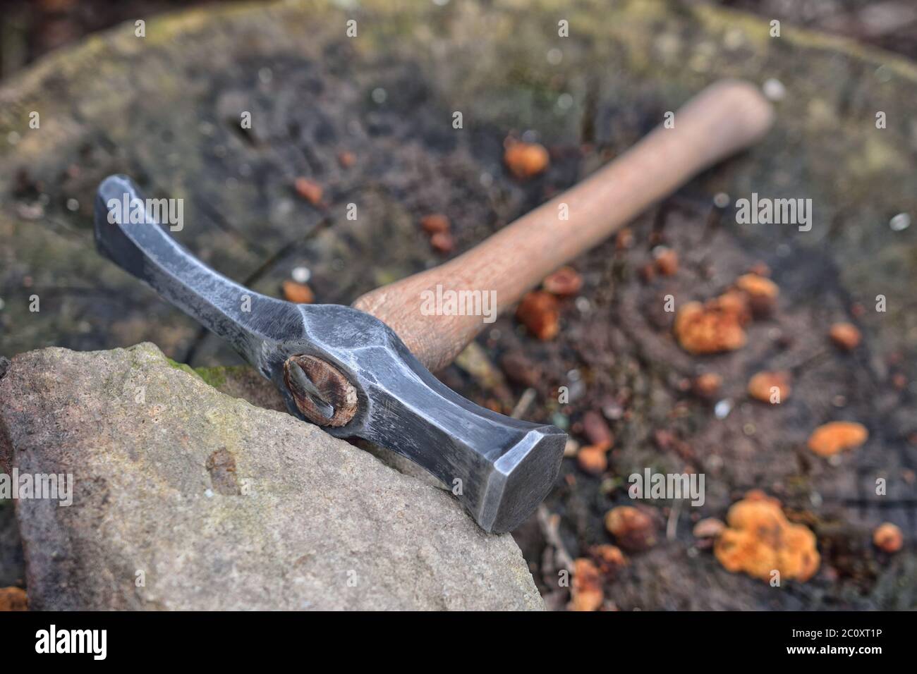 Martello fabbro fatto a mano che poggia su un moncone Foto Stock